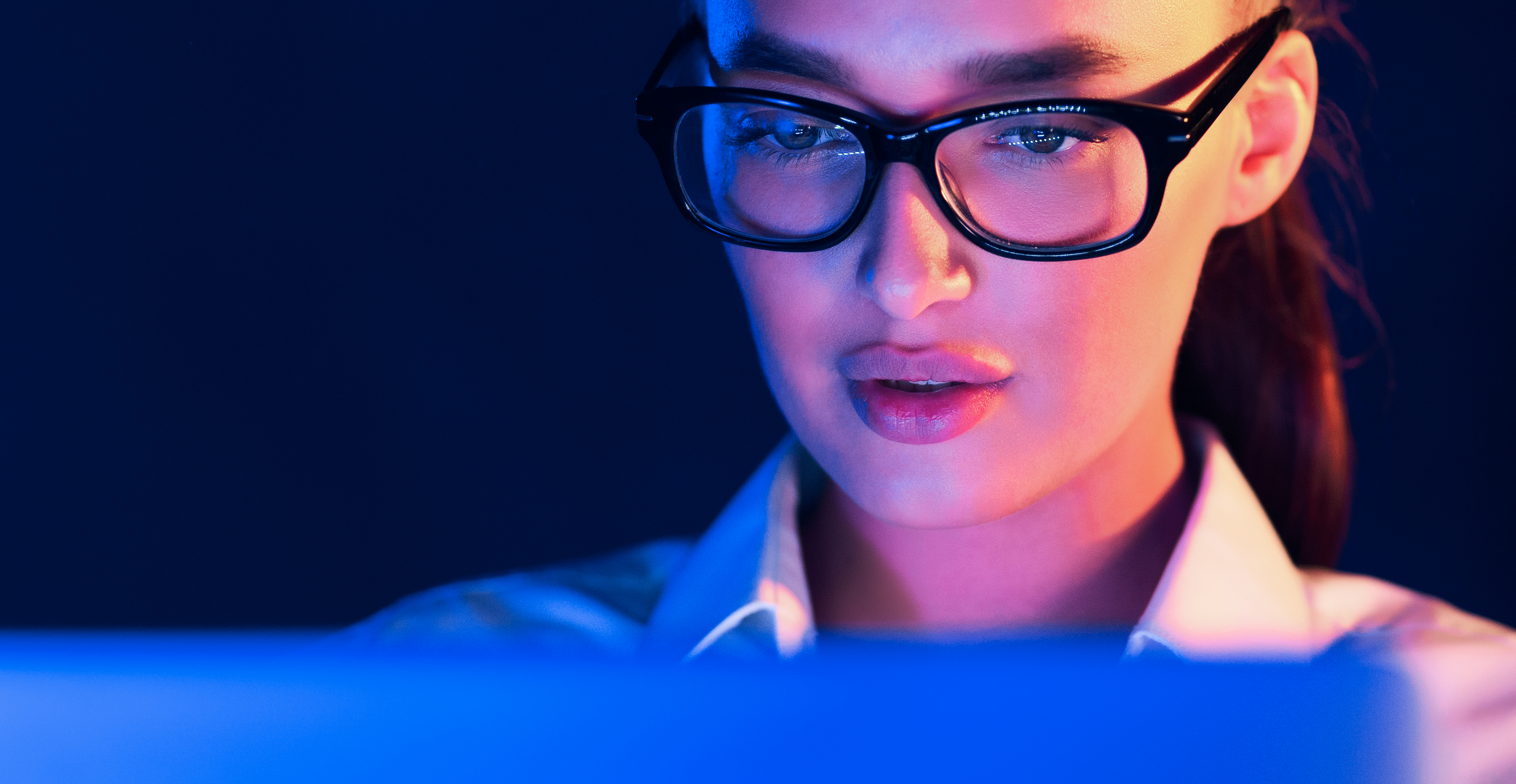 Donna che lavora al computer di notte: effetto della luce blu